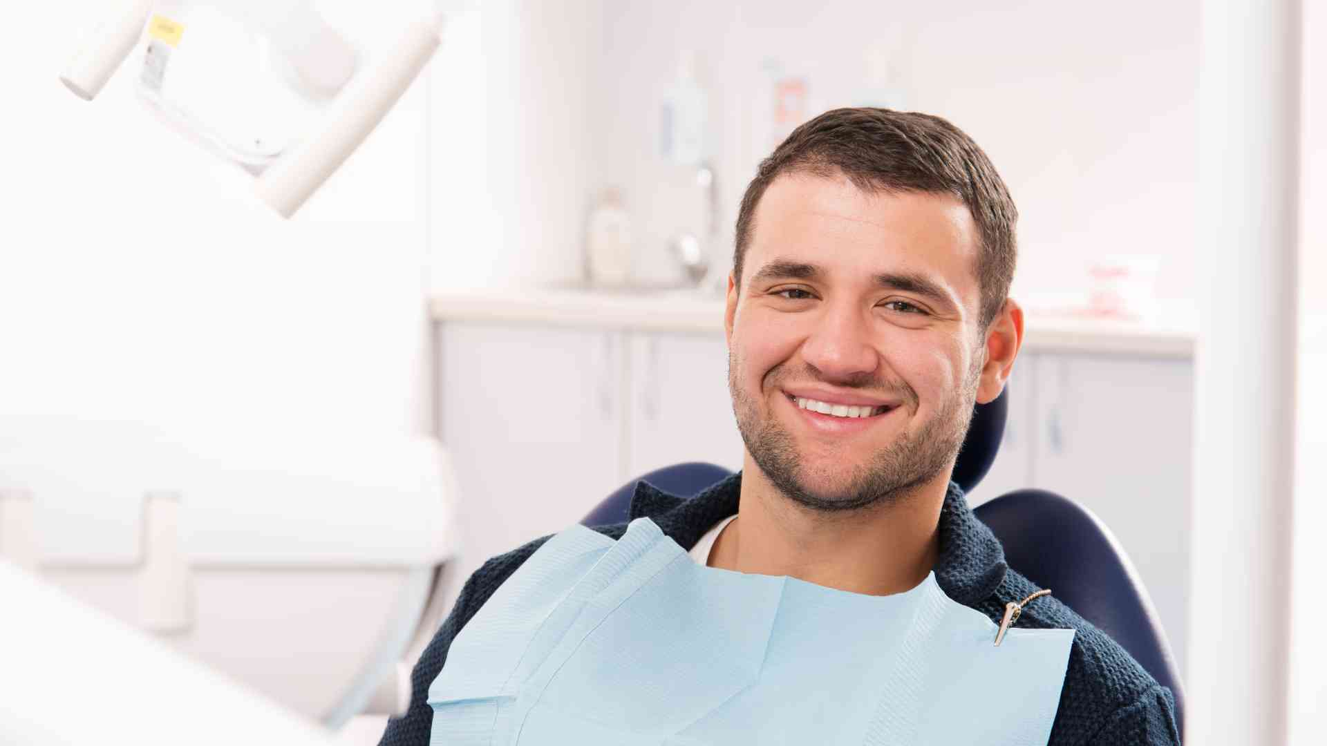 A relaxed male patient smiling comfortably in a modern dental chair